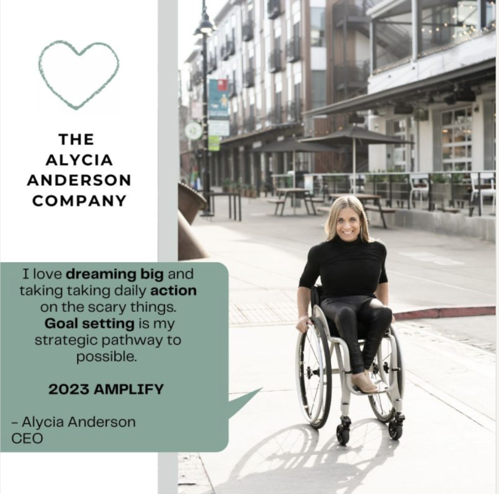 Alycia wearing black pushing wheelchair across the street with caption I love dreaming big and taking daily action on the scary things. Goal setting is the path way to possible. 2023 Amplify 